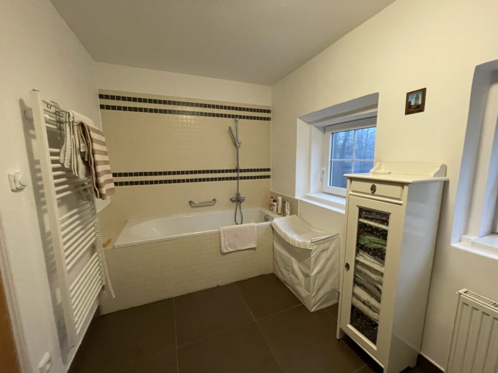 Velká koupelna v přízemí s oknem a vanou